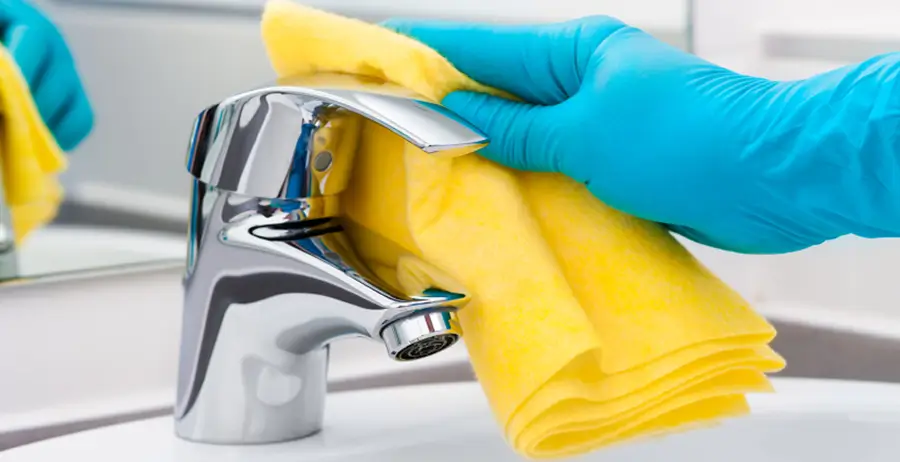 Cleaner wiping down bathroom sink