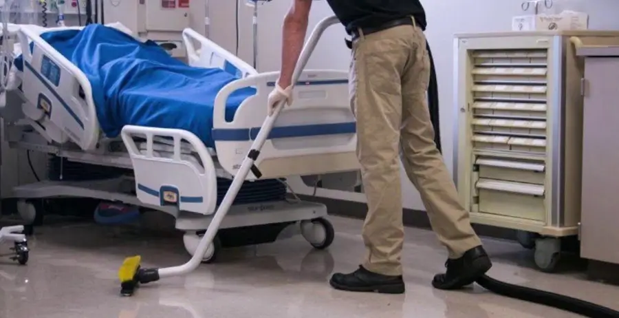 Janitor cleaning floor in a hospital room