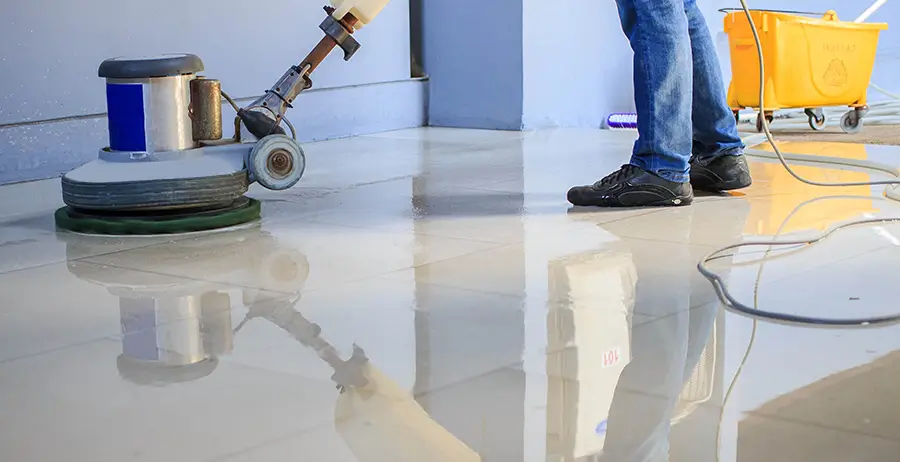 Floor waxing machine being used by a janitor