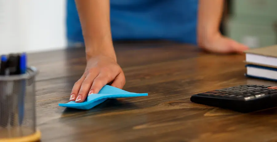 Janitor dusting office desk