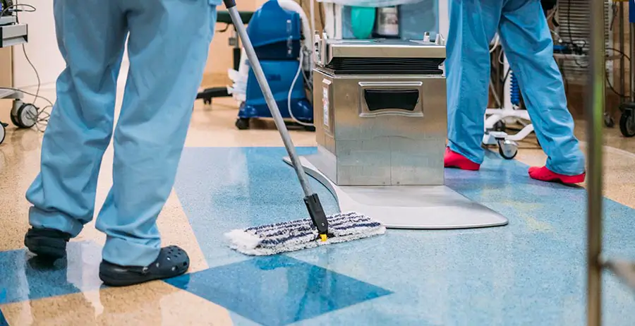 Team of janitors cleaning floor in healthcare facility