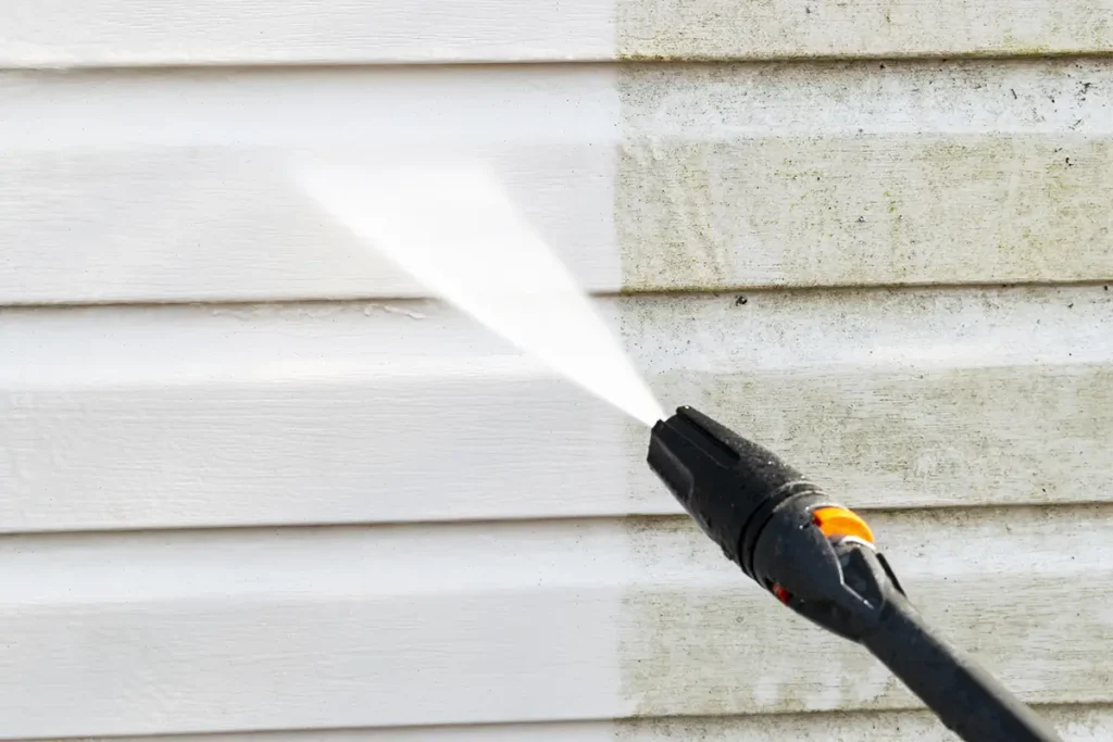 Power washer cleaning dirty home siding