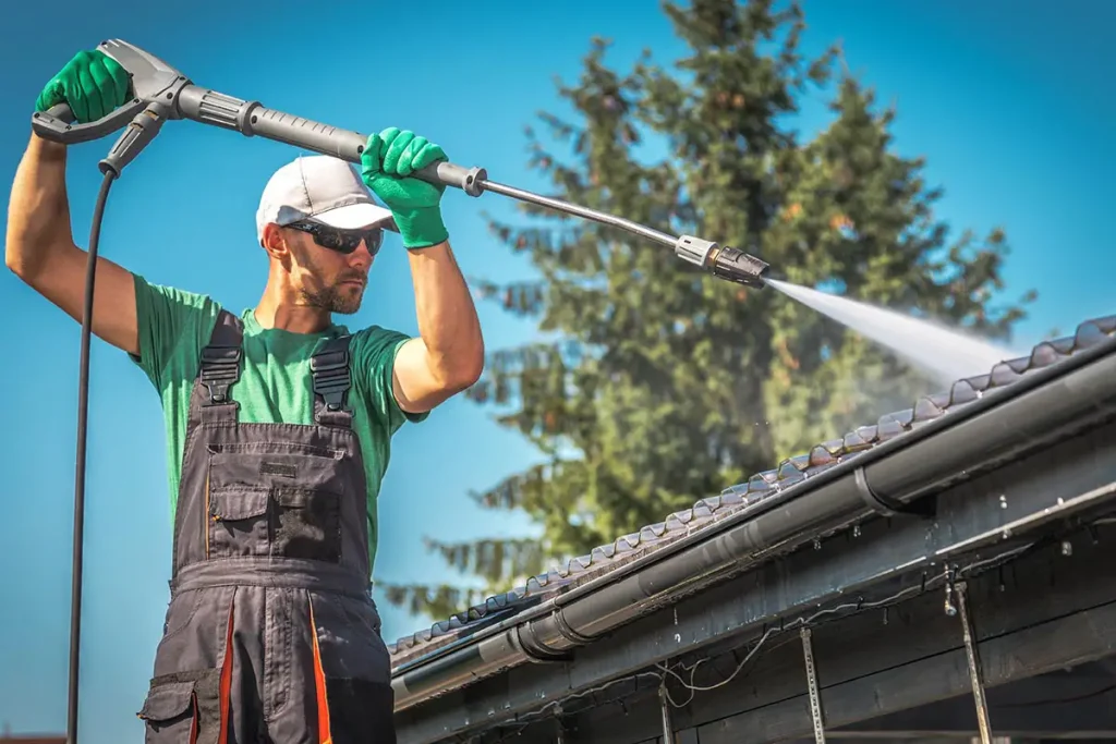 Power washer being used to clean roof and gutters